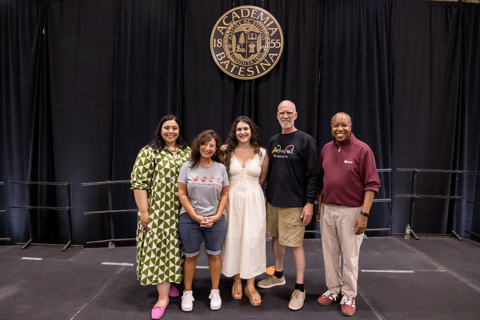 Five people standing on a stage
