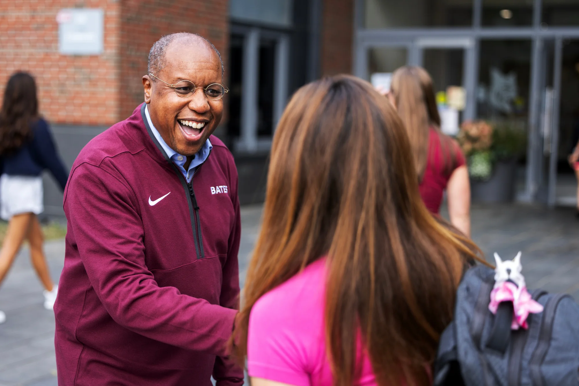 A smiling man shakes a woman's hand