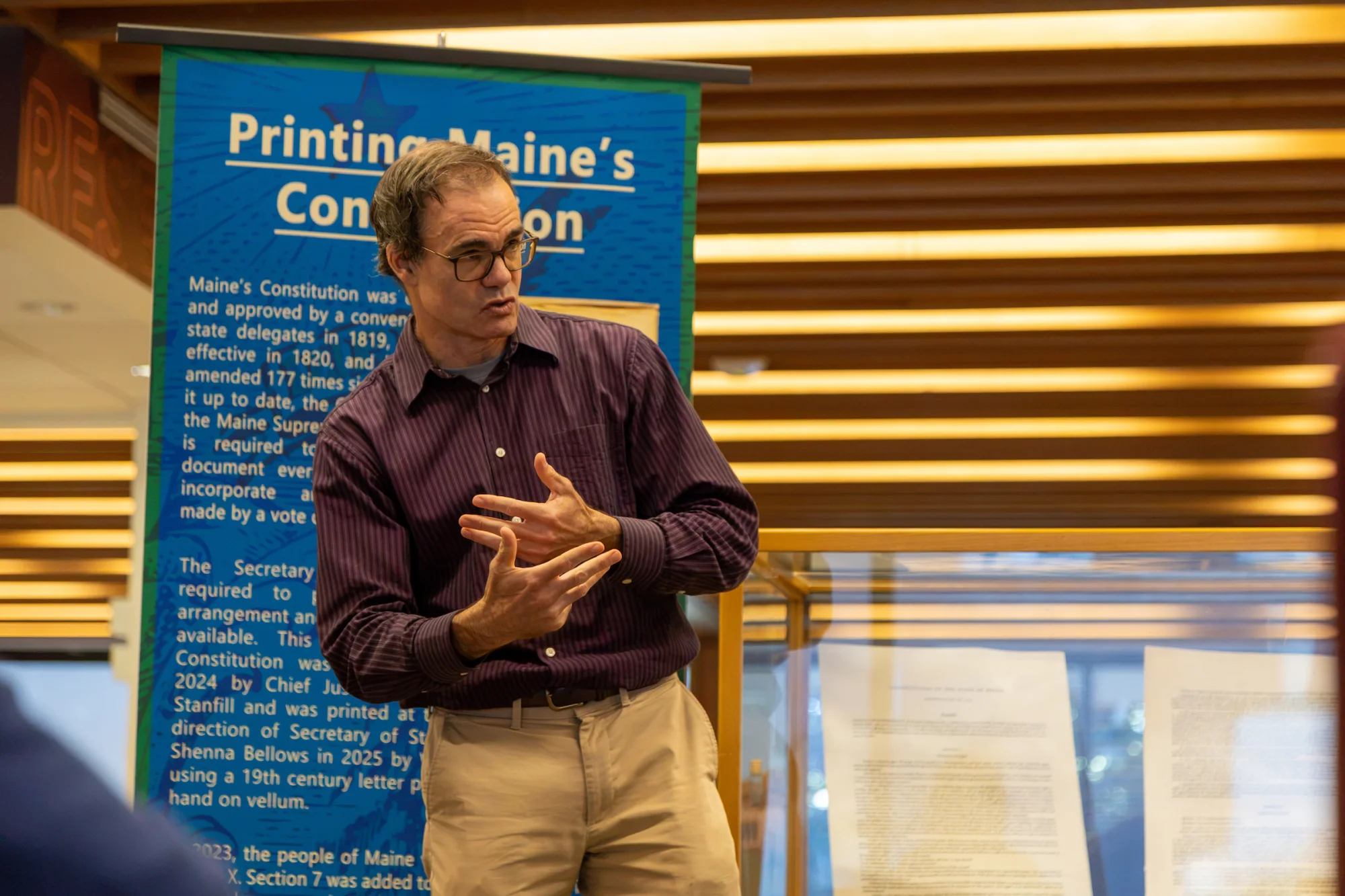 Associate Professor of History Joe Hall gives the background behind a new printing of the Maine State Constitution, which includes, for the first time in 150 years, three sections of Article X that had been redacted in 1876. From Sept. 21 to Oct. 1, Ladd Library hosted a display of three of the pages with restored language. Photo by Carly Philpott '27 for Bates College