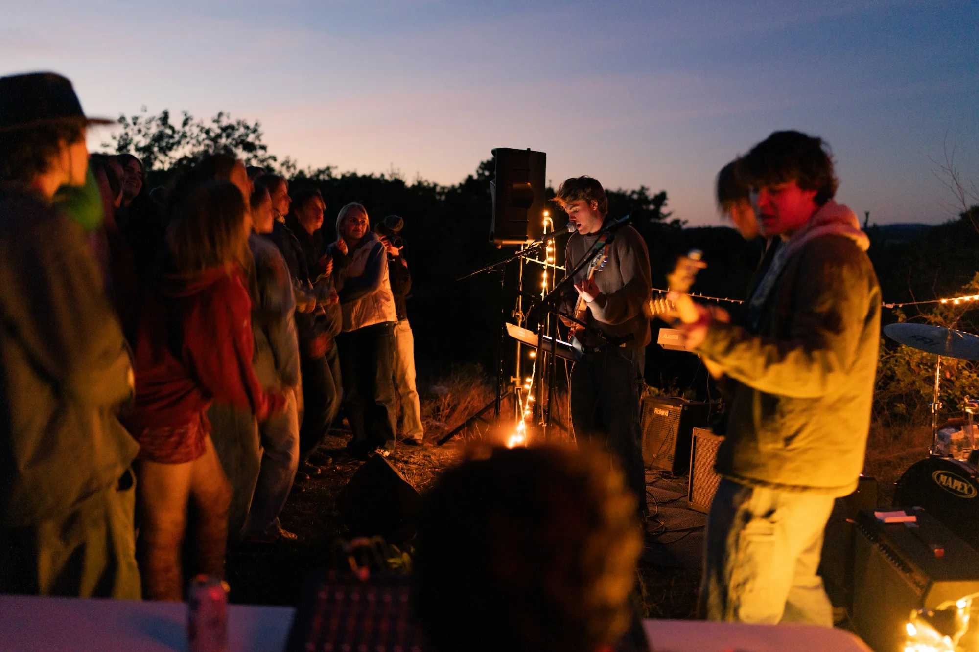 In the dark, people play music outside for an audience