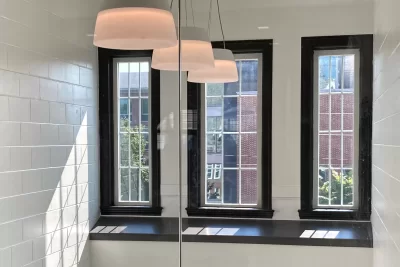 A view through glass of the lightwell from Chase Hall’s second-floor lobby. Applying black paint around the windows was among the last chores undertaken in the building’s 14-month makeover. (Doug Hubley/Bates College)