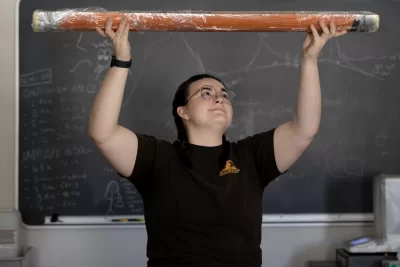 All the way from Greenland, Arctic soil samples give Bates professor, students a glimpse into ancient climate conditions

Hadley Blodgett ’26 of Buckfield, Maine, spends a lot of time thinking about just that — time.

In a laboratory in Carnegie Science Hall, as she conducts research for her senior thesis, Blodgett gazes over 7,000 years of history condensed into a sediment sample extracted from a lake in northern Greenland. As a double major in earth and climate sciences and music, with a minor in religious studies, Blodgett enjoys reflecting on the way that time has constructed and altered her fields of study. Sometimes, when the immensity of the sediment sample’s past hits her, she thinks, “How am I holding this?”
“To think about the scale of what's in front of me is just kind of crazy,” Blodgett says.
How exactly did sediment buried deep beneath Arctic waters find its way to the surface, then to Bates? The story crosses oceans and icebergs, tundras and deserts, but connects to  Bates through Blodgett’s thesis advisor, Associate Professor of Earth and Climate Sciences Nick Balascio.

As a paleoclimatologist, Balascio studies how Earth’s climate system has changed across millennia, primarily through analyzing lake sediment cores, which are layers of mud, dirt, and organic material extracted from the bottom of lakes in long tubes.

“Those lakes are natural history books that record what's going on around the watershed of the lake as well as within the lake itself,” Balascio says.