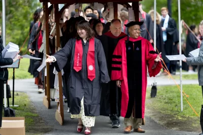 One Baccalaureate tradition is that the processional passes through archways adorned with prayers, poems, and blessings offered by parents, guardians, and other loved ones. Here the processional, led by President Garry W. Jenkins, makes its way through the Class of 2026 archway on May 30, 2026. (Phyllis Graber Jensen/Bates College) 