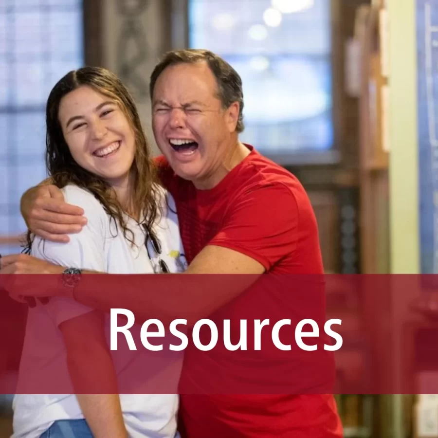 a father humorously pretending to cry while hugging his daughter, while she laughs