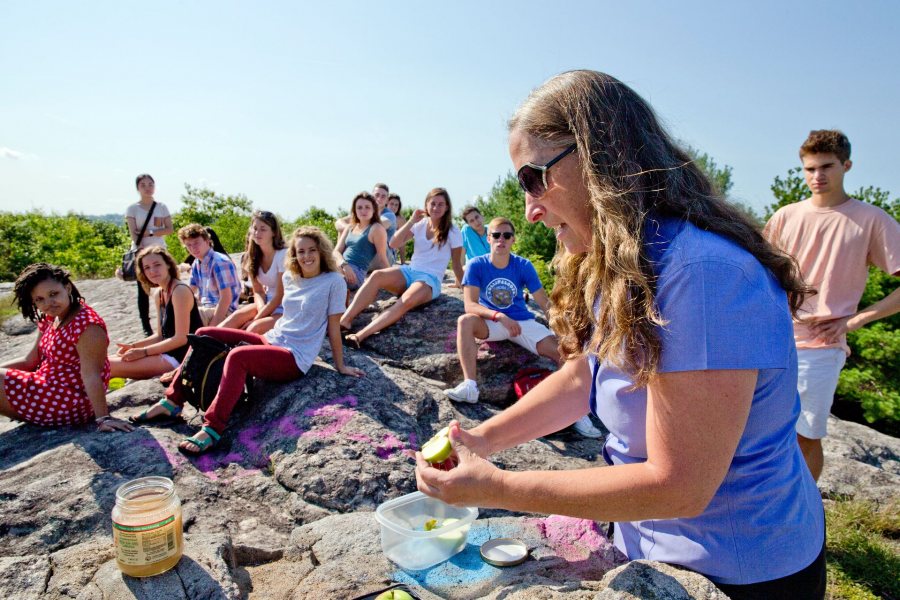 Associate Professor of Religious Studies Cynthia Baker slices an apple for students in her first-year seminar, "The Nature of Spirituality." She asked them to dip the fruit into honey as an expression of hope for a sweet school year. The ritual is inspired by an age-old Jewish New Year tradition. Baker and her students had just climbed Mount David, a 389-foot granite outcropping near campus, where they followed the apples and honey with a discussion of "Nature," a Ralph Waldo Emerson essay published in 1836. Today, all members of the Class of 2019 met with their first-year seminar instructors for class discussion and academic advising