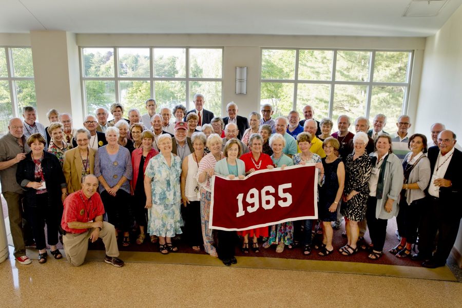 Members of the Class of 1965 pose for a class picture in Pettengill Hall's Perry Atrium.