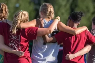 Students with their back to the camera and arms around eachother in a line