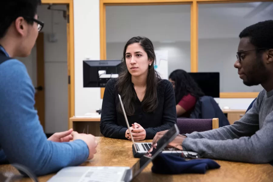 Hilton Chao '18 of Taiwan, Maria Maza '18, and Durotimi Akinkugbe '18 of London, listen to each other while studying at a table in the Academic Resource Commons. (Theophil Syslo/Bates College)