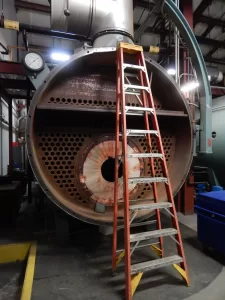 One of three boilers in Bates' central steam plant, at Cutten Maintenance Center, this unit's original combustion unit has been removed to make way for a new Renewable Fuel Oil burner. (Doug Hubley/Bates College)
