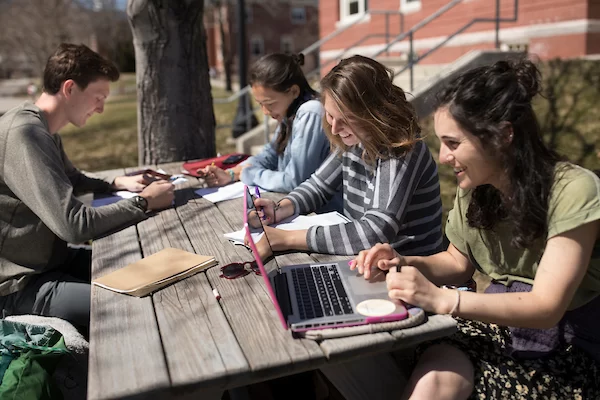 Studying on picnic table outside of the Roger Bill after their first day of Short Term classes:
Nick Holmes, Grace Warder, Nora Finley, and Sophia Thayer.

The first day of Short Term is, you might say, a homerun, every member of the Bates community seems to be out and about soaking up the sunshine. (Phyllis Graber Jensen/Bates College)