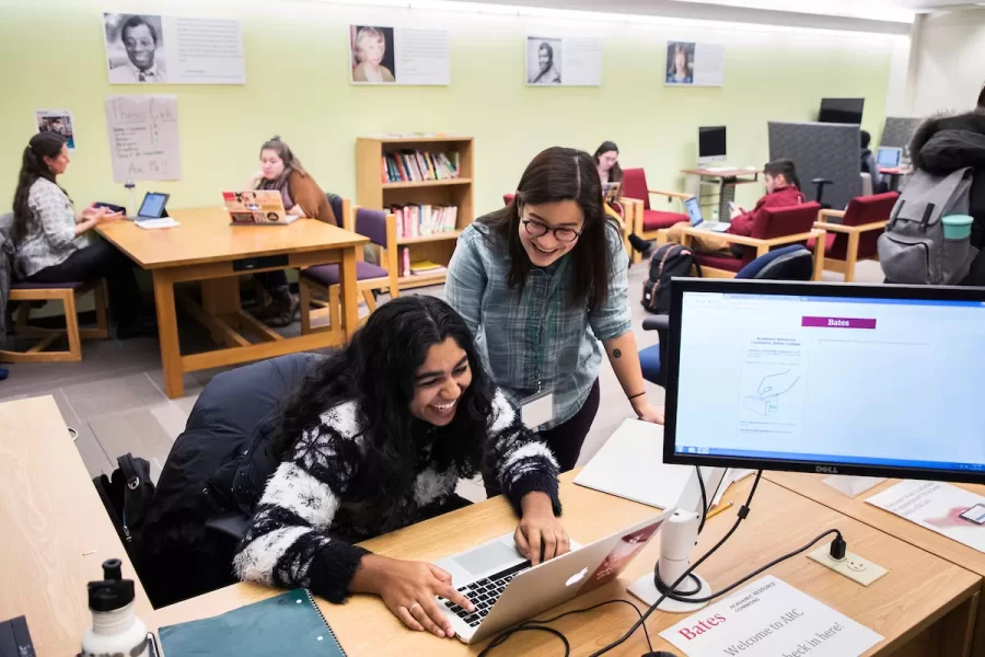 Zofia Ahmad '19 of Palo Alto, Calif., student manager, reacts while working on a slideshow presentation with Kiyona Mizuno '18 of San Francisco, student manager, in the Academic Resource Commons. (Theophil Syslo/Bates College)