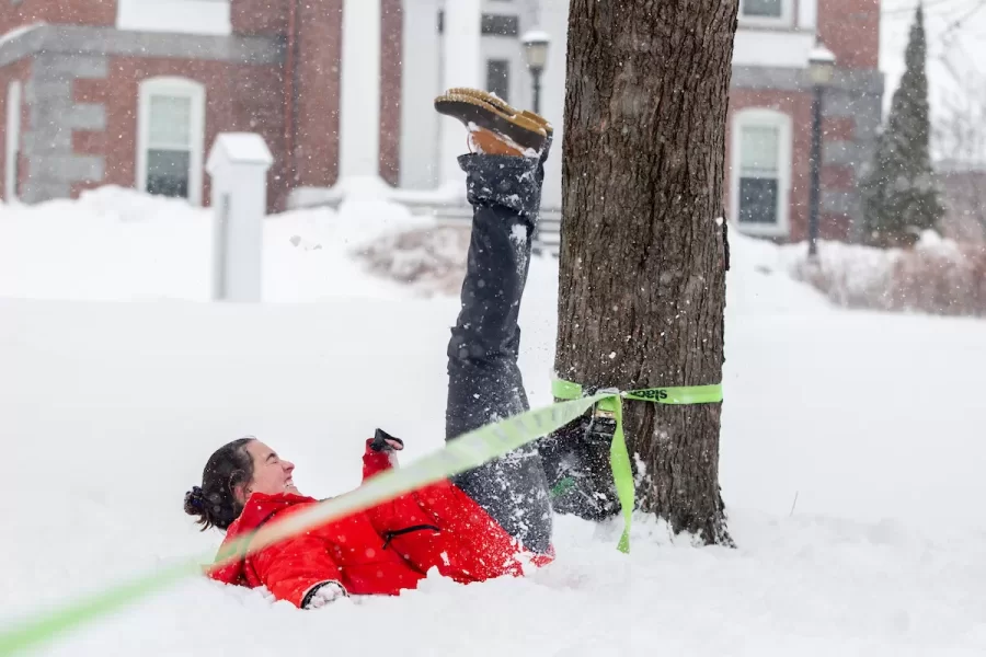 Big wet snowflakes fall on Friday, Feb. 15, 2019. After a day indoors, three friends decided they needed some outdoor time, so the snowfall brought them onto the historic Quad with a slack line. In orange jacket: Sally Porter '21 of Washington, D.C. 